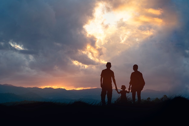 写真 4人の幸せな家族が夕日を見てください。