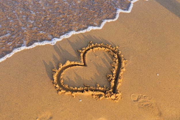 Фото Сердце ждет на песчаном пляже у моря.