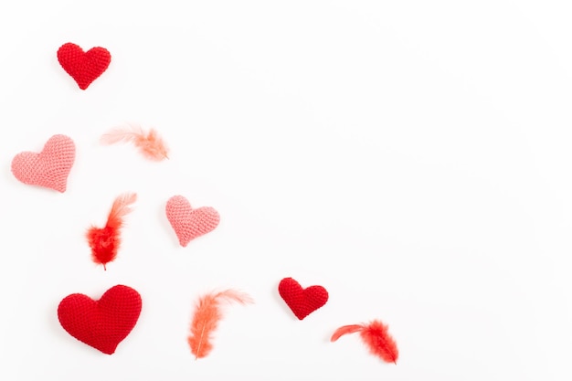 사진 2월 14일 발렌타인 데이 배경을 위한 니트 하트와 깃털 배너가 있는 휴일 카드 공간 복사 평면 위치 평면도