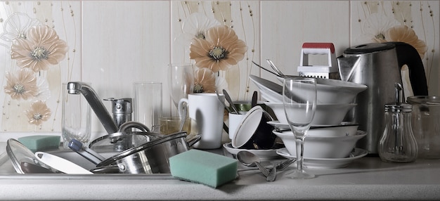 Фото Огромная куча немытой посуды в кухонной раковине и на столешнице