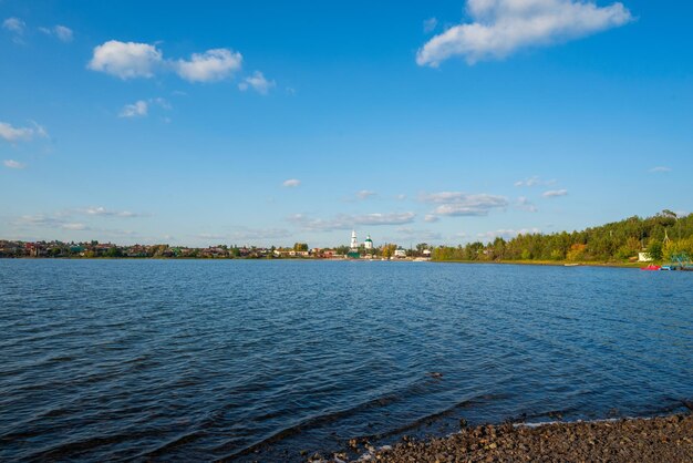 写真 晴れた秋の日に村の背景にある湖