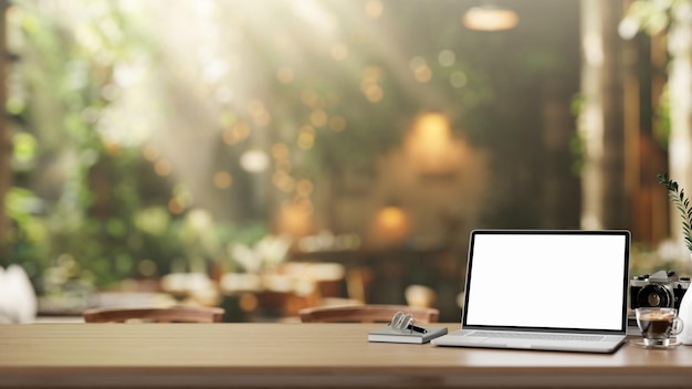 Фото Ноутбук с белым экраном на деревянном столе в красивом кафе.