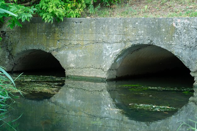 사진 고속도로 아래 강을 우회하기 위한 대형 콘크리트 파이프 대형 콘크리트 파이프에서 새는 더러운 물 파이프에서 나오는 더러운 하수 환경 오염 환경 문제
