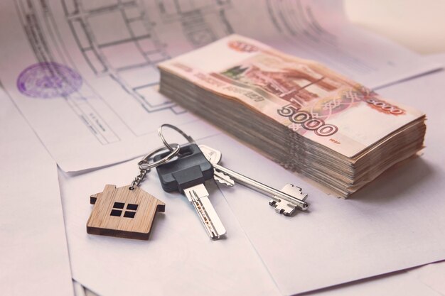 Фото На плане квартиры крупная сумма российских денег и ключи. время покупать. ипотечный кредит банка на покупку недвижимости