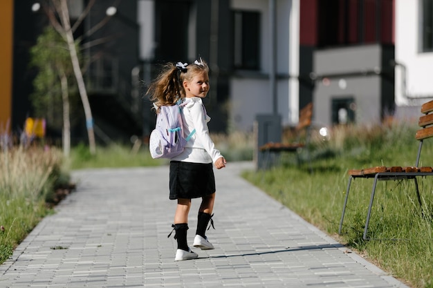 写真 少女は小道沿いの公園を通って学校に通っています。遠隔教育のコンセプト。女子高生