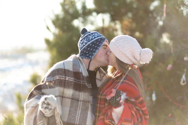 写真 暖かい格子縞の愛情のあるカップルが花火を手に持ってキス