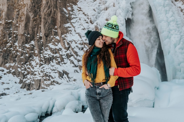 写真 休暇中の冬の山で愛する若いカップル。男と女は旅行中です。