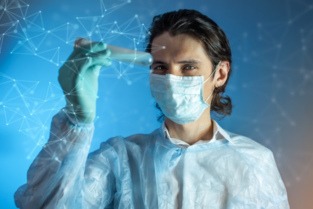 Фото Мужчина-врач, ученый-фармацевт держит пробирку с вакциной против вируса, разработанной в лаборатории.