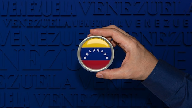Мужская рука держит значок с национальным флагом венесуэлы на синем фоне