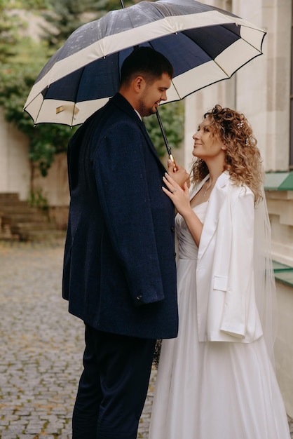 Фото Мужчина и женщина стоят под зонтиком.
