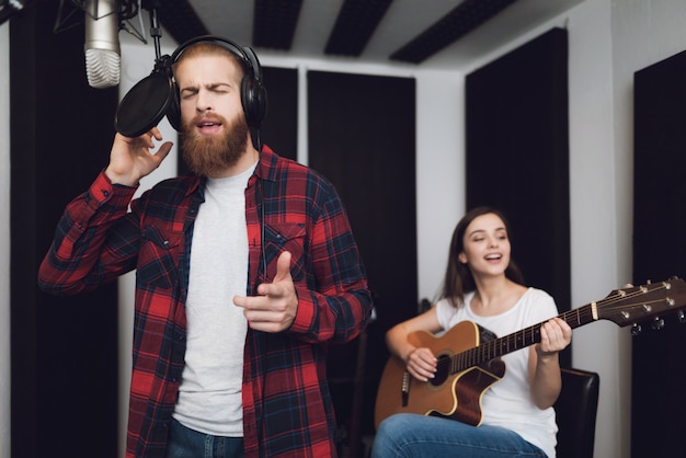 Фото Мужчина и женщина поют песню в студии звукозаписи.