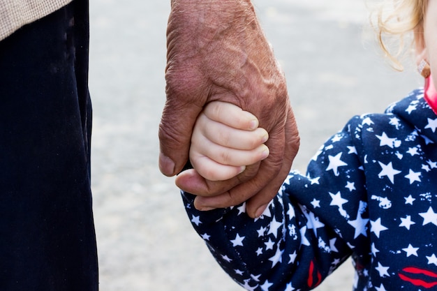 写真 歩きながら小さな女の子の手を握る男