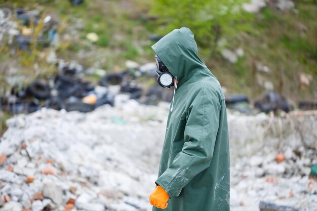 写真 保護マスクと保護服を着た男性が危険地帯を探索する生態学的災害の選択的焦点