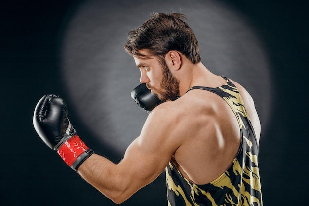 Фото Мужчина в боксерских перчатках мужчина боксирует на черном фоне концепция здорового образа жизни