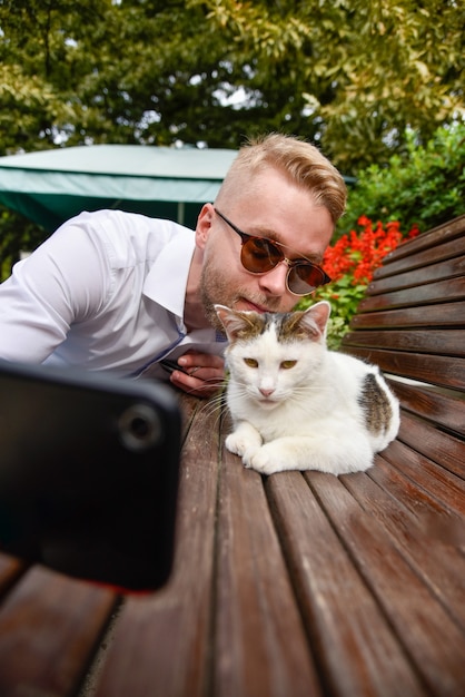 野良猫がベンチに座っている男性を撮影