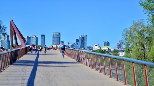 写真 バイクに乗って橋を下りて背景に街がある男性