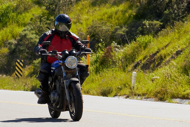 写真 「i'm a'on it」と書かれた標識のある道路でオートバイに乗っている男性