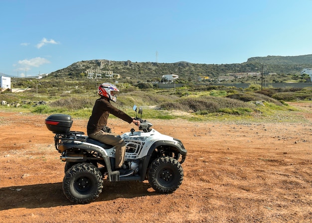 写真 保護ヘルメットの砂でatvに乗る男