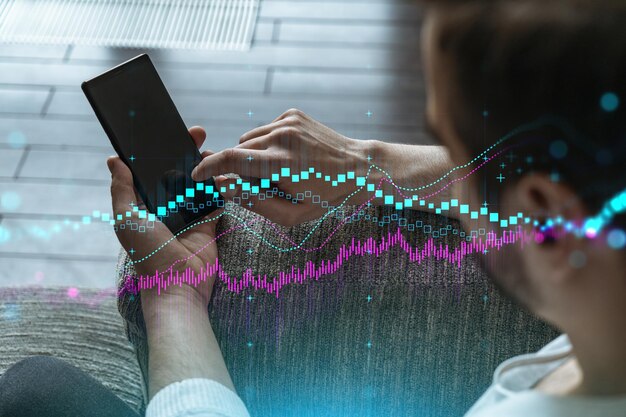 사진 스마트 폰을 사용하는 남자 이중 노출 forex 그래프 홀로그램 금융 거래 온라인 중개 개념