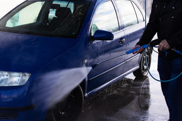 写真 洗車場で車を洗う男