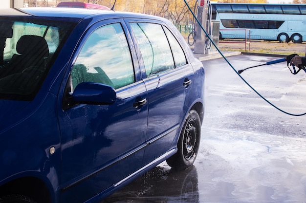 写真 洗車場で車を洗う男