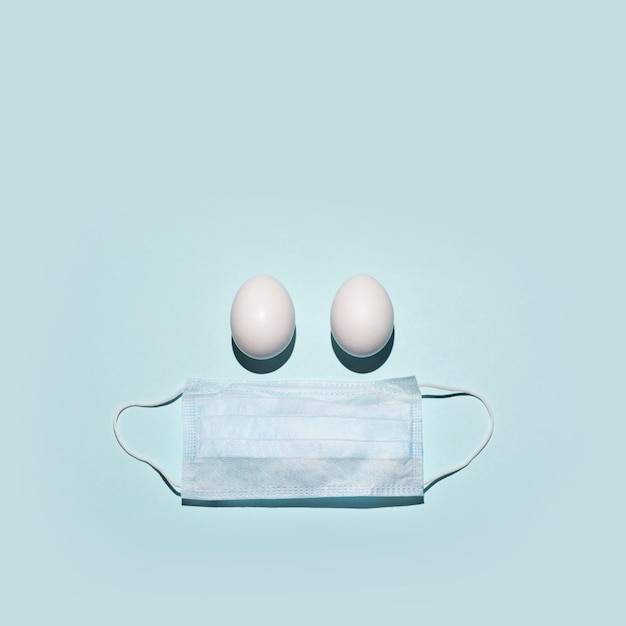 写真 イースター2020のコンセプトの目の代わりに医療用マスクと2つの卵