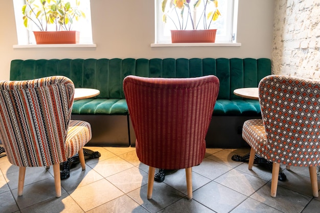 사진 다채로운 덮개를 씌운 의자와 편안한 소파가 있는 현대적인 아늑한 레스토랑 거친 콘크리트 벽과 천장에 목재 장식 기둥이 있는 특이한 카페 디자인