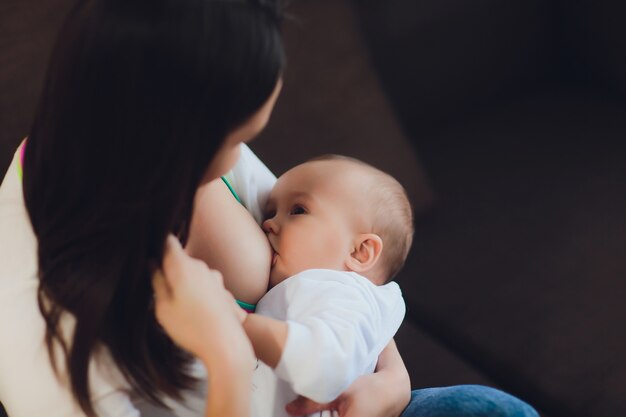 사진 그녀의 팔에 그녀의 작은 아기를 모유 수유하는 어머니