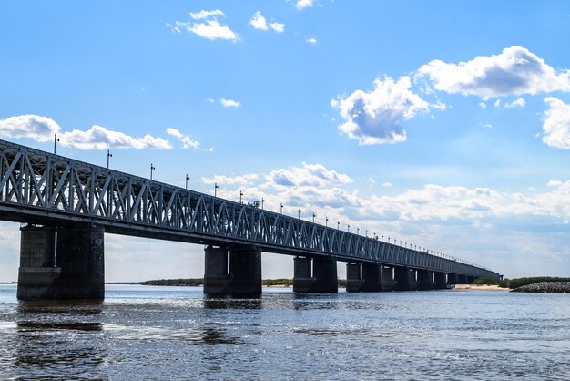 写真 川を横断する高速道路と鉄道の橋 青い静かな川の水と青い雲の空
