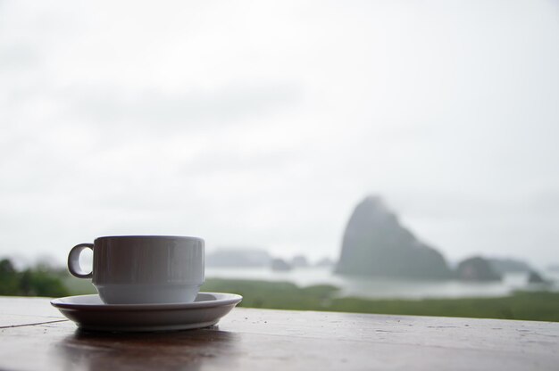 写真 白いコーヒーマグを持つ山の背景