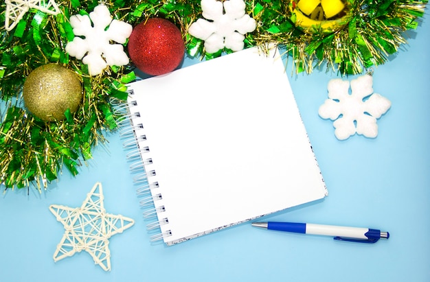 写真 ペンとクリスマスの装飾新年の青い背景を持つメモ用のメモ帳