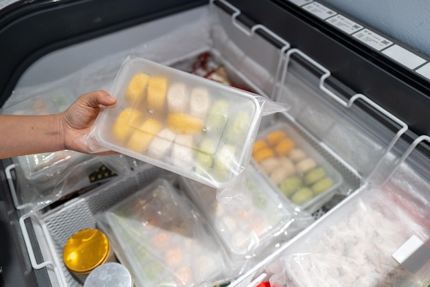 Фото Пара рук, которые выбирают еду в холодильнике