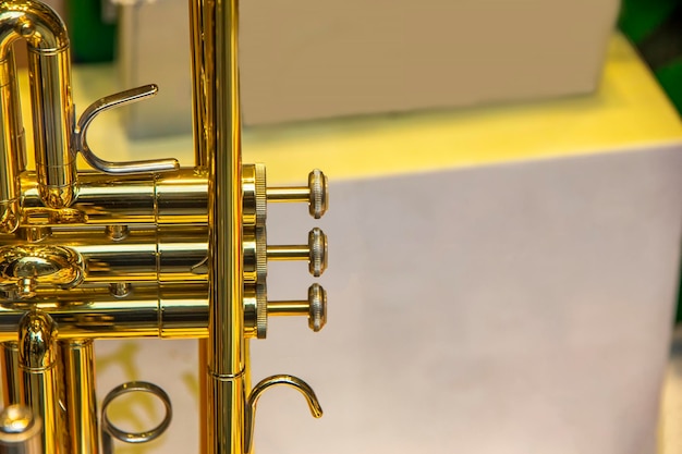 Фото Часть потрясающей золотой трубы с латунными деталями крупный план клапанов кнопок пальцев трубы