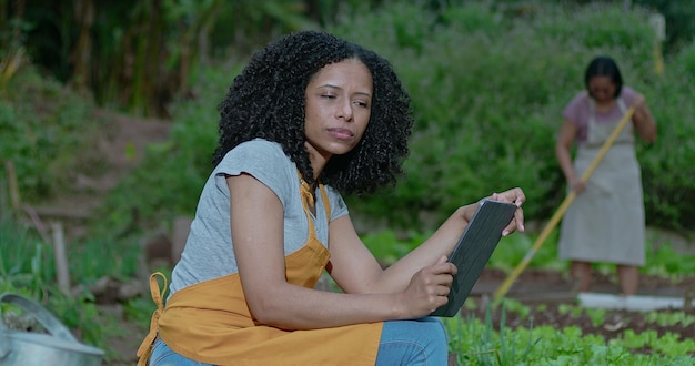 Фото Задумчивая чернокожая женщина на городской ферме с планшетом задумчивая афроамериканка на местной ферме малого бизнеса