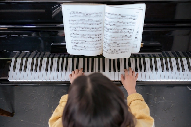 사진 a person is looking at a piano with a sheet of music on it