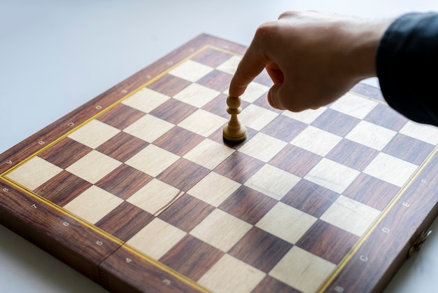 Фото Рука человека делает ход в шахматной партии, думает о стратегии