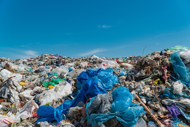 写真 青い空を背景に埋め立て地のゴミの山 埋め立て地のプラスチックスクラップ エコロジーの概念