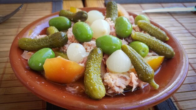 Фото Тарелка еды с солеными огурцами и луком на ней