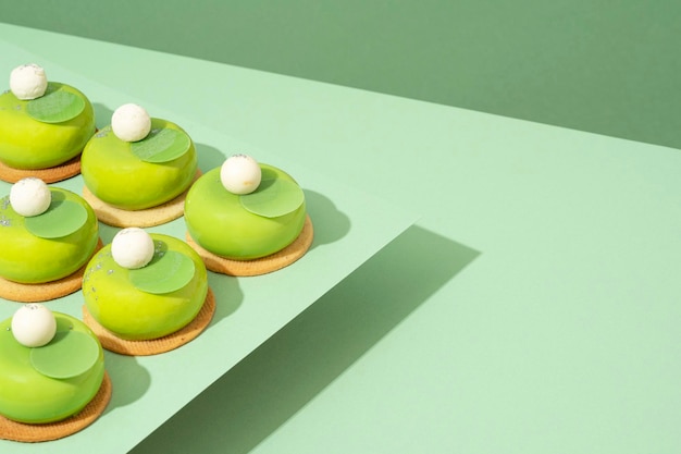 사진 여러 가지 녹색 도넛이 담긴 플래터가 나무 테이블 위에 놓여 있습니다.