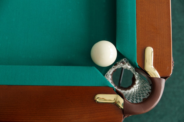 Фото Бильярдный стол. вид сверху. мяч катится в карман. игорный стол