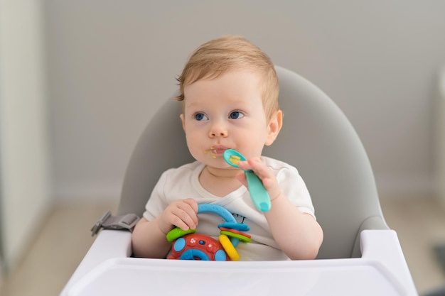 写真 ハイチェアで幸せな若い男の子の肖像画は野菜を食べる幸せな幼児の男の子