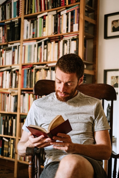 写真 家で本を読んで赤い頭の男性