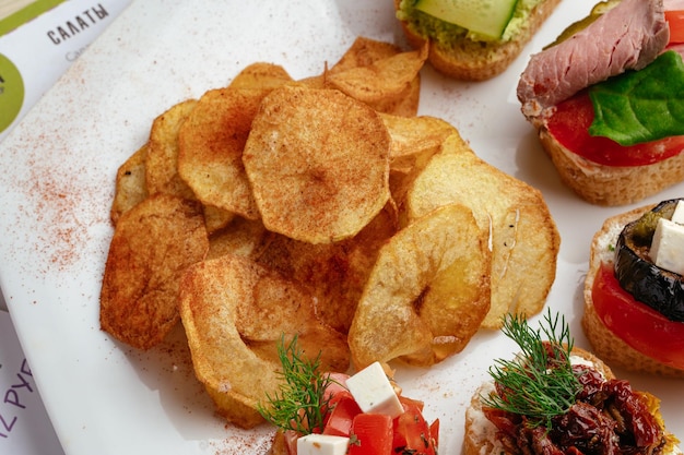 Фото Выбор блюд, включая бутерброд, чипсы и помидоры.