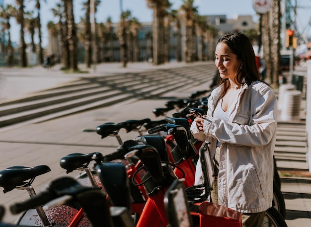 写真 バルセロナの静かな春の午後笑顔の女性が自転車を借りている