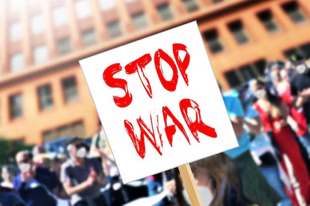 Фото В толпе висит плакат с надписью «стоп войне».