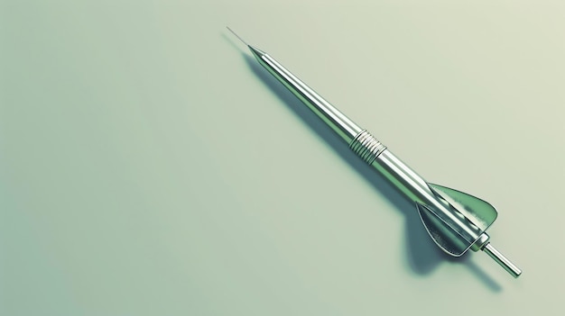 Фото Серебряная металлическая стрела с острым наконечником и одним стабилизирующим плавником лежит на бледно-зеленой поверхности