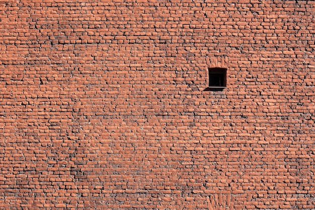 Фото Одно окно в огромной кирпичной стене солнце освещает стену