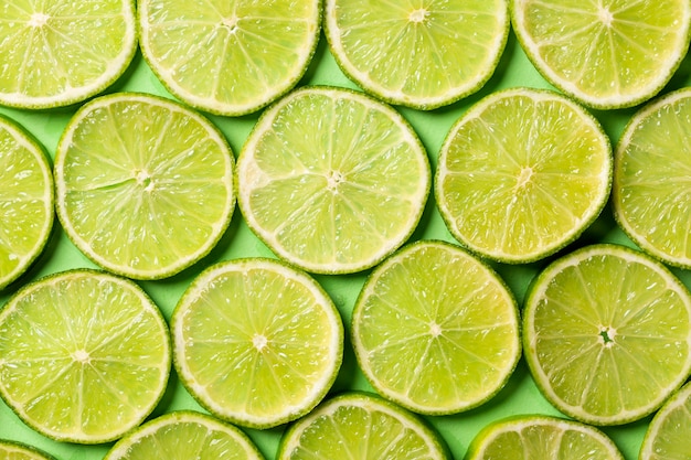 新鮮なジューシーなグリーンレモンの背景のスライス