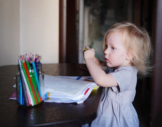 写真 小さな子供がテーブルに描画します