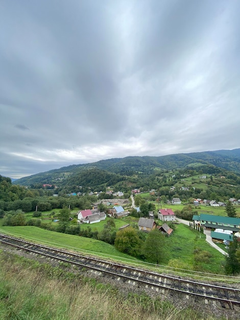 写真 山の中の小さな村 森の岩 雲 美しい風景 ヨーロッパ 伝統的な木造家屋と鉄道